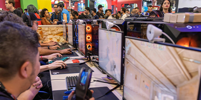 Close up image of a line of people gaming in the game room at AnimeCON.