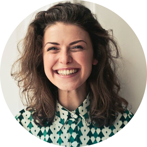 Headshot of voice actress Mary Jane, a brunette woman who is smiling at the camera