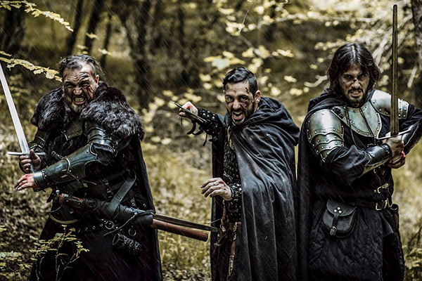 three main actors brandishing swords and screaming