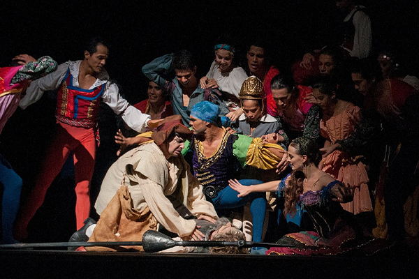 actors on stage around a fallen member