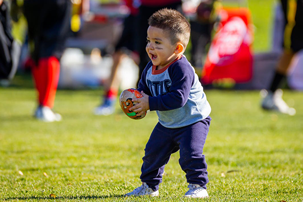 Little Jimmy holds a toy football in his hand